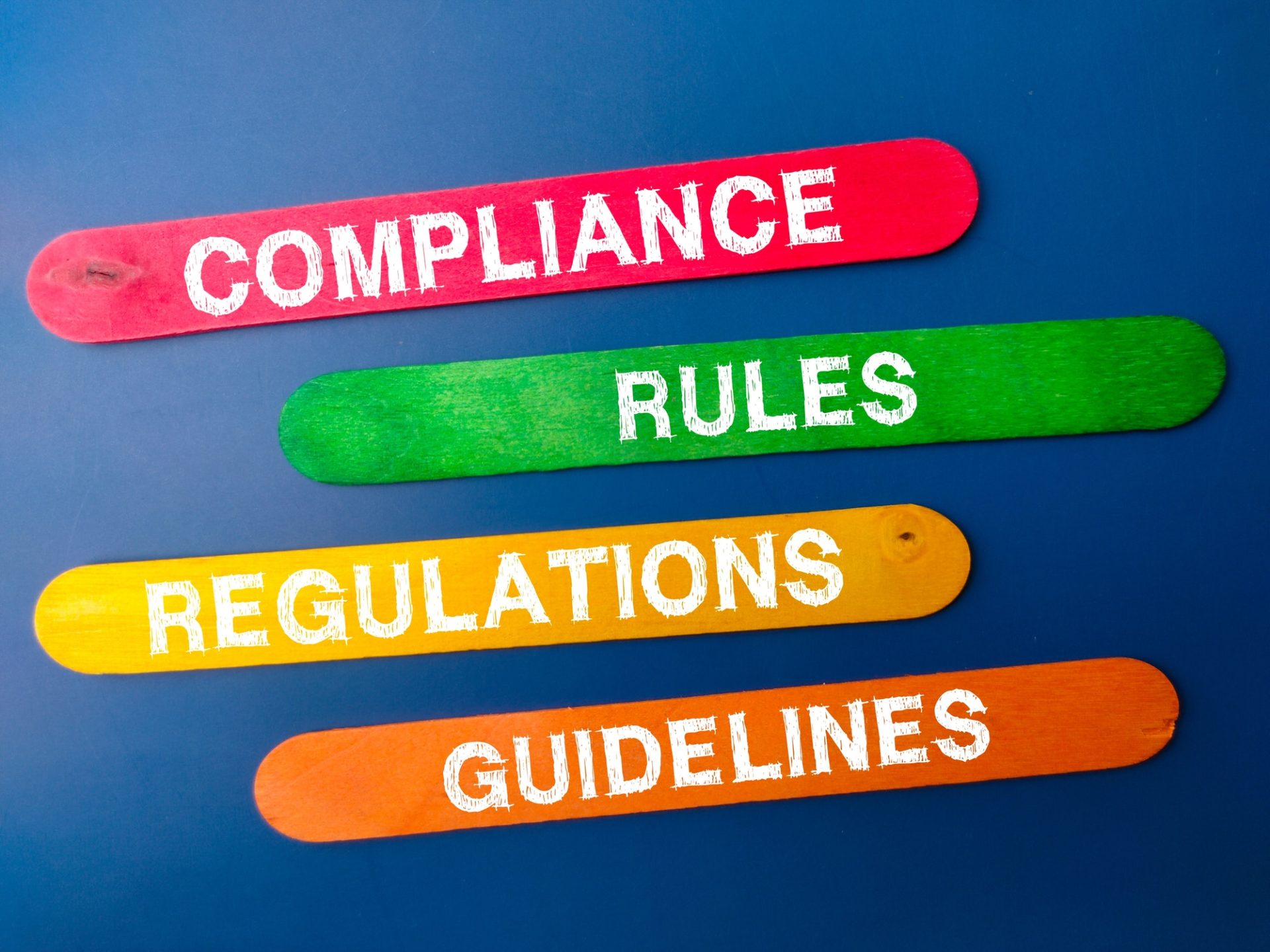 Colored ice cream stick with the word COMPLIANCE RULES REGULATIONS GUIDELINES.